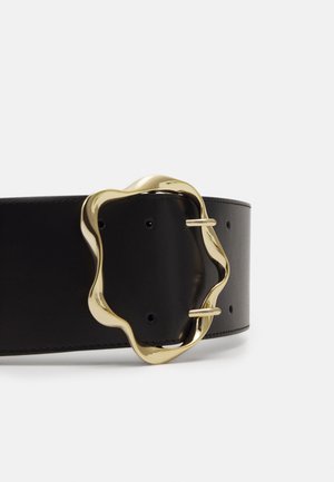 Zwarte leren riem met een onregelmatige golvende gouden metalen gesp die twee punten toont door de gaten in de riem.