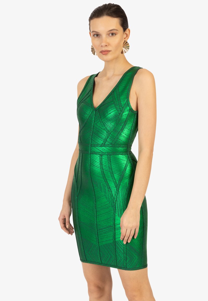Robe sans manches verte en matériau texturé et brillant avec des motifs géométriques. Design ajusté avec un décolleté en V profond et une longueur mi-cuisse.