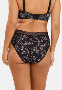 Lingerie noire à motif floral avec une taille ornée de dentelle ; elle présente un tissu doux et une coupe haute pour un ajustement confortable.