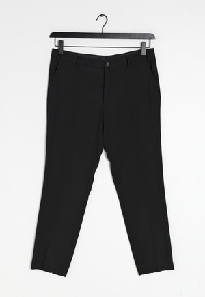 Czarne spodnie o dopasowanym kroju, z bocznymi kieszeniami, pojedynczym zapięciem na guzik oraz gładką fakturą materiału. Wiszą na czarnym wieszaku.
