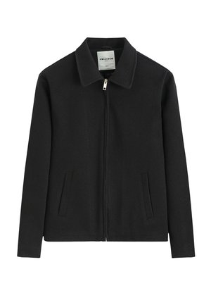 Veste noire zippée avec col et deux poches fendues à l'avant, en tissu texturé, posée à plat sur fond blanc.