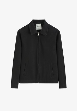 Veste noire zippée avec col et deux poches fendues à l'avant, en tissu texturé, posée à plat sur fond blanc.