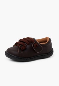 Braune Lederkinderschuhe mit runder Spitze, strukturierten Schnürsenkeln und Klettverschluss. Weiches Innenfutter und flexible schwarze Gummisohle.