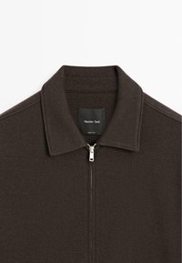 Brązowa kurtka na zamek z płaskim kołnierzem, miękka w dotyku, z metalowym zamkiem. Posiada czarną metkę z logo "Massimo Dutti".