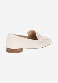 Beige suede loafers with a rounded toe, flat wooden heel, and a decorative strap across the front. Smooth texture, minimalist design.