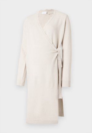 Vestido envelope bege feito de um tecido suave, com um decote em pico, mangas longas e um laço lateral. Comprimento longo com punhos canelados.