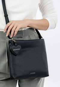 Black leather handbag with a pebble texture, adjustable strap, and a heart-shaped charm featuring "EMILY&NOAH" in silver lettering.