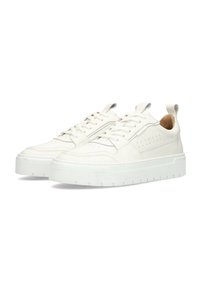 Zapatillas deportivas blancas de cuero con una superficie texturizada, diseño de cordones y perforaciones minimalistas. Suela de goma gruesa con un ligero plataforma.