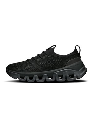 Chaussure de sport noire avec dessus en maille texturée, fermeture à lacets et semelle coussinée segmentée pour le soutien et la flexibilité, vue de côté.