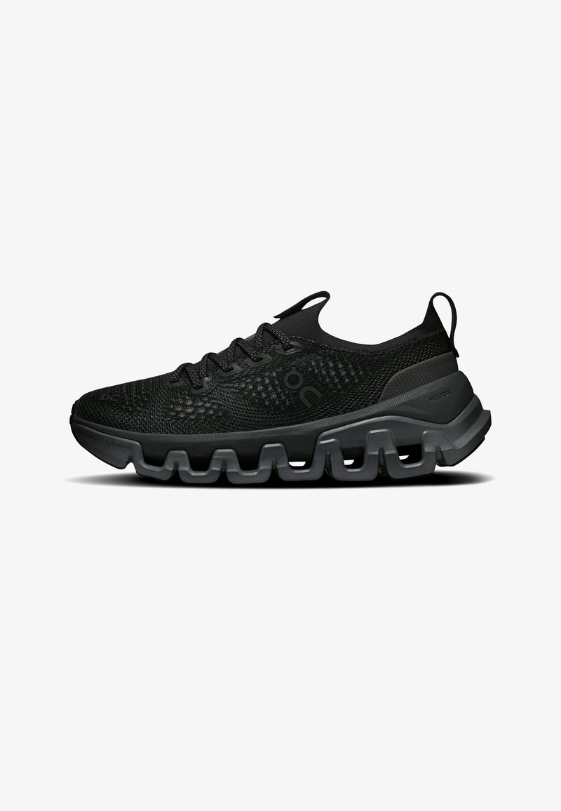 Chaussure de sport noire avec dessus en maille texturée, fermeture à lacets et semelle coussinée segmentée pour le soutien et la flexibilité, vue de côté.