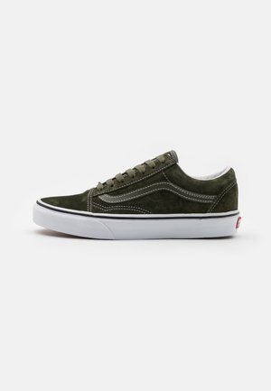 Baskets en nubuck vert olive avec semelle en caoutchouc blanc et accents noirs, présentant un design cousu et des lacets plats. Vue de profil.