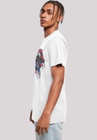 White cotton t-shirt featuring a graphic design of a superhero, with a round neckline and short sleeves, casual fit.