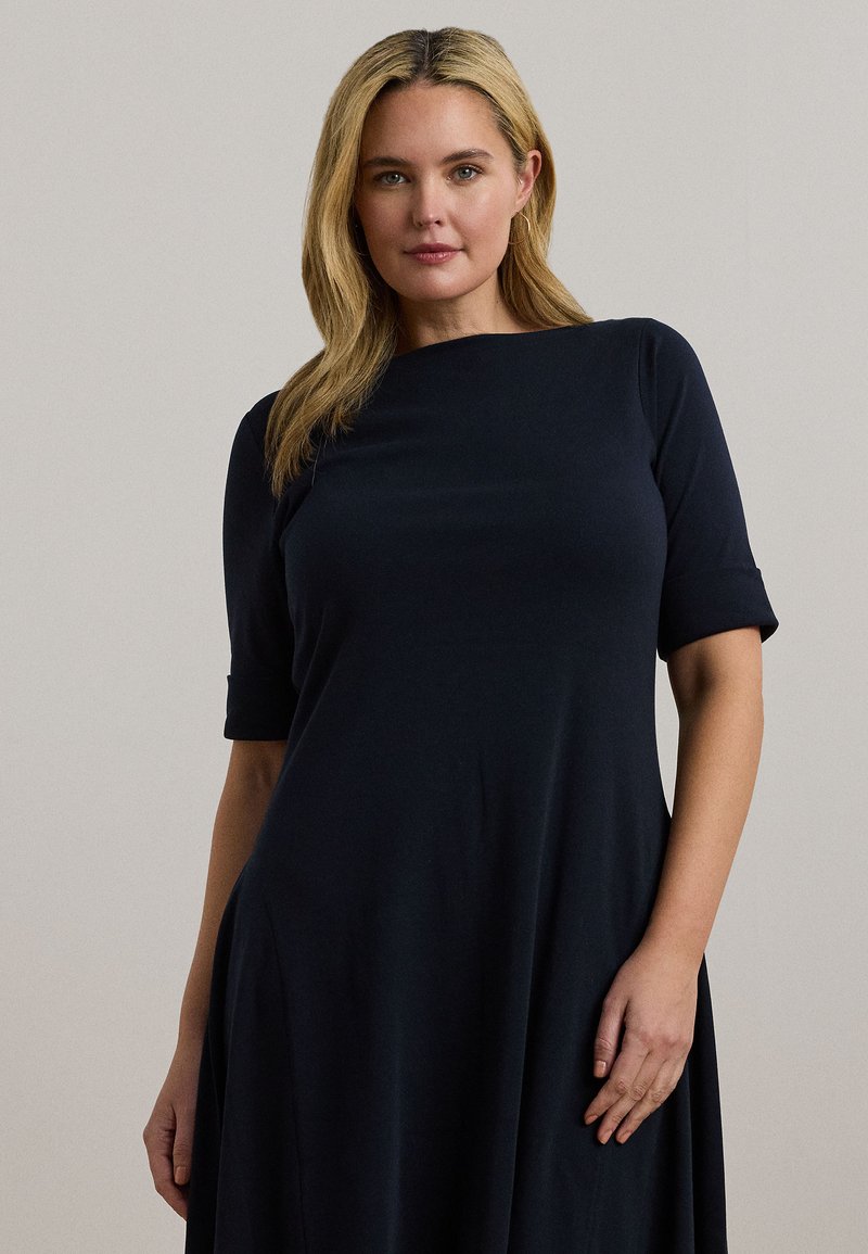 Σκούρο ναυτικό φόρεμα από μαλακό, ελαστικό ύφασμα. Διαθέτει στρογγυλή λαιμόκοψη, κοντά μανίκια και φαρδιά σχεδίαση που κρέμεται από τη μέση.