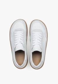 Białe niskie trampki z gładką skórzaną cholewką, wzmocnionym noskiem, perforowanymi detalami i teksturowaną tanową gumową podeszwą.
