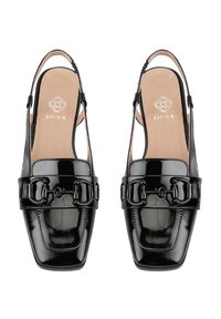Chaussures slingback en cuir verni noir avec un bout carré et une sangle décorative comportant un détail en chaîne métallique sur le dessus.