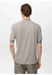 T-shirt a maniche corte a righe in grigio chiaro e beige. Tessuto morbido con scollatura rotonda e orlo curvo. Presenta tatuaggi visibili sulle braccia.
