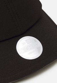 Cappello regolabile nero con visiera curva e tessuto testurizzato; presenta un'etichetta argentata che indica stile e taglia.