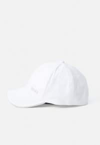 Hvid baseballcap lavet af bomuld, med en buet skygge, sekspanelers design og prægede logo på fronten. Glat tekstur.