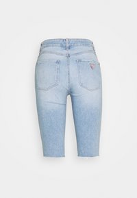 Shorts en denim bleu clair avec un effet délavé, dotés d'une taille haute, de deux poches arrière et d'un petit logo sur la poche droite.