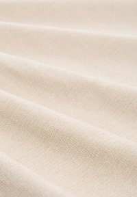 Bēša teksturēta auduma ar mīkstu pinumu, kas raksturots ar smalkām toņu variācijām un gludu, vienmērīgu virsmu. Piemērots dažādiem pielietojumiem.