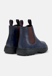 Botine din piele de nuanță bleumarin, cu panouri laterale elastice de culoare maro, talpă din cauciuc negru și manșete pentru o încălțare ușoară. Design cu vârf rotunjit.