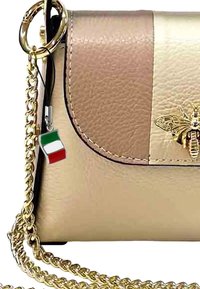 Sac à bandoulière en cuir doré et beige avec un motif d'abeille, une bandoulière en chaîne dorée et un pendentif ressemblant au drapeau italien. Texture lisse.