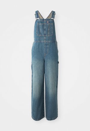 Salopette en denim avec jambes larges, bretelles réglables, poche avant et couleur bleue délavée. Fabriquée en coton robuste.