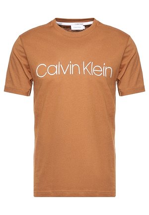 Brun bomulds t-shirt med rund hals og korte ærmer, prydet med "Calvin Klein" logo i hvidt henover brystet.
