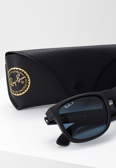 Черни слънчеви очила Ray-Ban с квадратни рамки, сини лещи и текстурирана черна кожена кутия с акценти в златисто.
