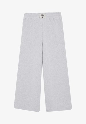 Hellgraue Hosen mit weitem Bein, elastischem Bund und einem kleinen Aufnäher mit der Aufschrift "KEEP GOING ON" in der vorderen Mitte.