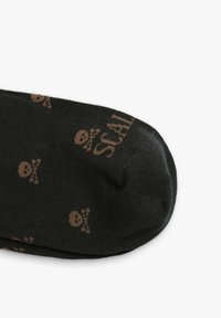Sorte sokker med små brune kraniummønstre. Designet inkluderer en forstærket tå og en glat, blød tekstur.