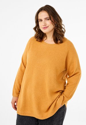 Mustard yellow sweater with a rounded neckline, long sleeves, and soft texture. Features a relaxed fit and is paired with dark gray trousers.