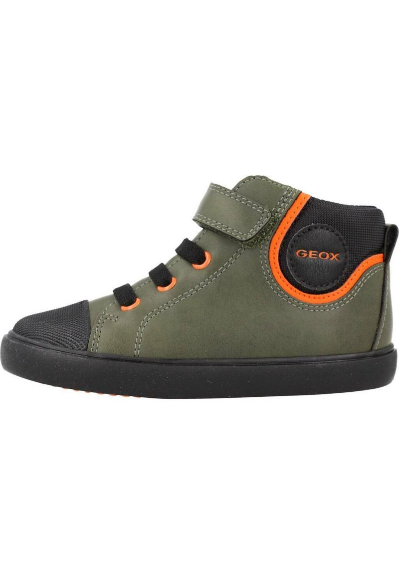 Chaussure montante verte avec accents noirs, semelle en caoutchouc et détails orange. Présente une sangle en Velcro et un design à bout rond. Logo de la marque visible.