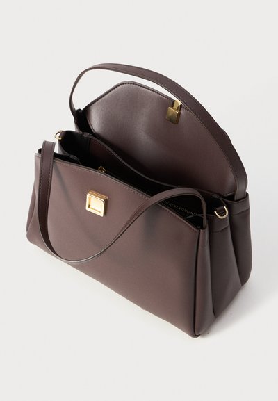 Brown leather handbag with a gold hardware accent, rectangular shape, and an open top revealing two compartments. Textured finish.