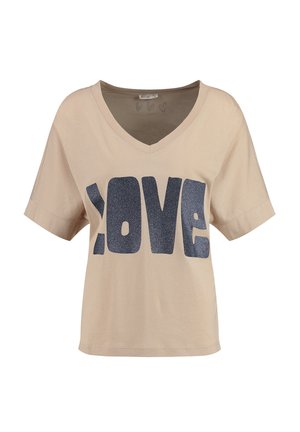 T-shirt en coton beige avec un col en V et des manches courtes. Présente un grand texte pailleté bleu foncé en lettres capitales disant "AMOUR" sur le devant.