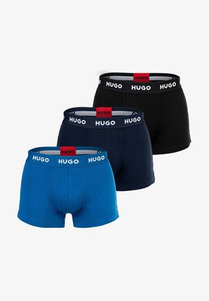 Drei Paare von Boxershorts in Blau, Dunkelblau und Schwarz. Jede trägt einen Logo-Bund mit einem kontrastierenden roten und weißen Design.