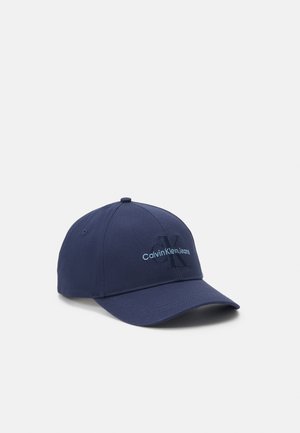 Casquette de baseball bleu marine avec une visière courbée et le logo Calvin Klein Jeans brodé en bleu clair sur le panneau avant.
