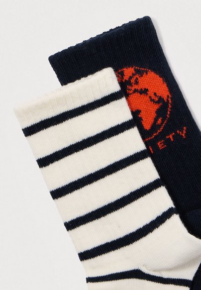 Divas zeķes, viena balta ar horizontālām melnām svītrām, un viena melna ar sarkanu apļveida Zemes dizainu un daļējiem tekstiem.