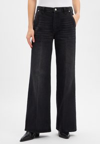 Zwarte wijde spijkerbroek met een hoge taille, gemaakt van denim, voorzien van voorzakken, riemlussen en een subtiele vervaagde textuur.