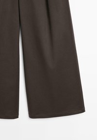 Bruine wijde broek gemaakt van soepele stof, met een rechte snit en afgezette randen, zonder zichtbare patronen of versieringen.