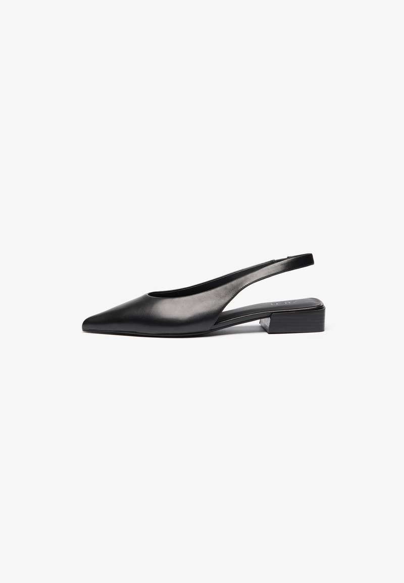 Chaussure noire en cuir à bride arrière avec un bout pointu, des côtés ouverts et un petit talon bloc. Texture lisse avec un design minimaliste.
