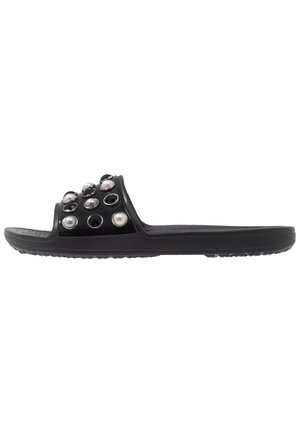 Black slide sandal featuring a glossy upper adorned with round black and pearl-like decorative accents, flat sole with textured grip.