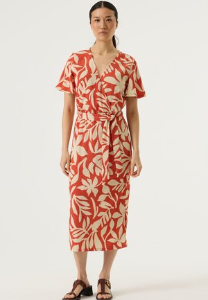 Rode en ivoorkleurige wikkeljurk met korte mouwen, textuurstof, knie-lange zoom en een detail met een strik in de taille. Soepele, vloeiende uitstraling.