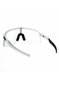 Białe i czarne okulary sportowe z przezroczystym przodem, gumowymi noskami i zakrzywionymi zausznikami. Posiadają srebrny metalowy mostek i logo.