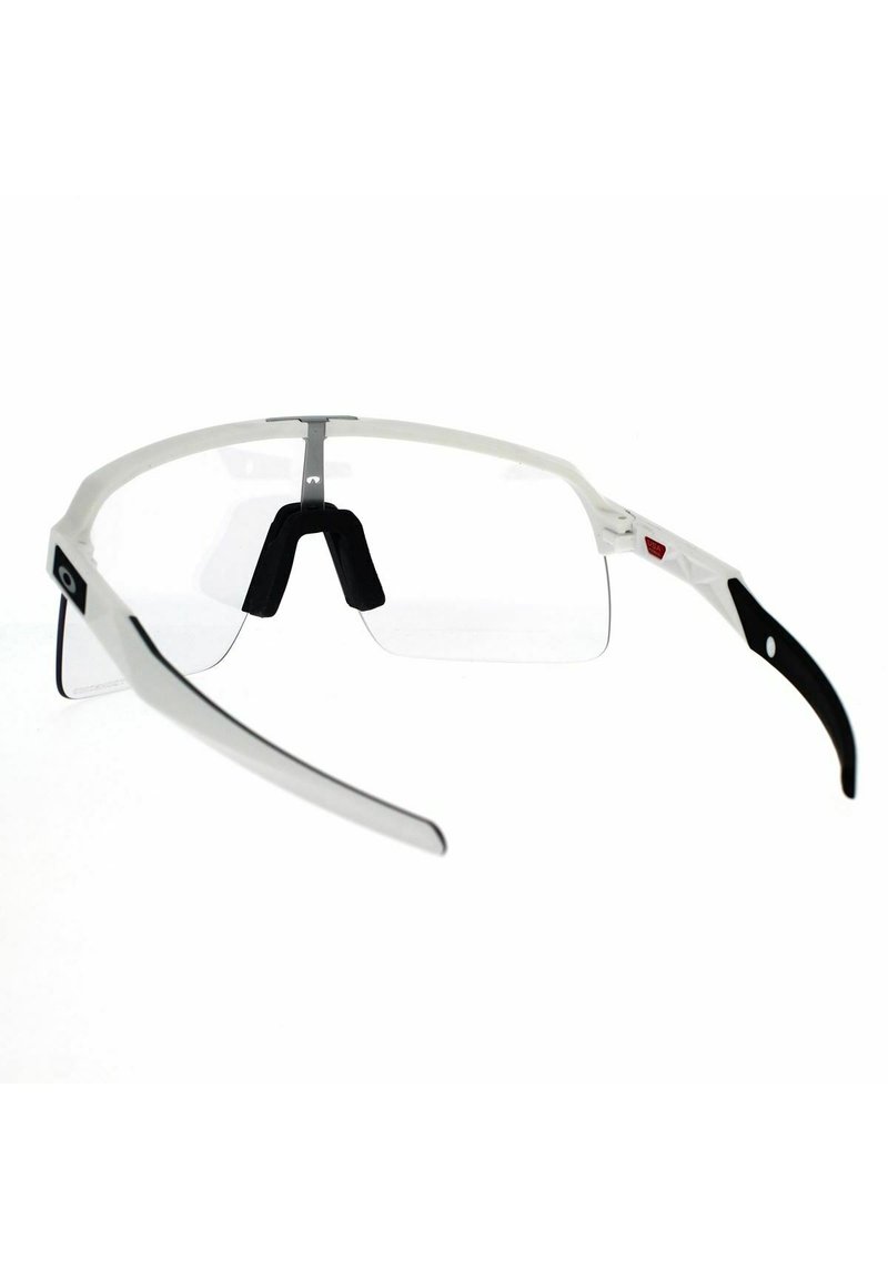 White and black sports glasses with a transparent front, rubber nose pads, and curved earpieces. Features a silver metal bridge and logo.