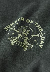 Ciemnoszara bluza z nadrukiem kreskówkowej postaci jeżdżącej na rolkach oraz napisem "JUMPER OF THE DAY" w pogrubionej czcionce.