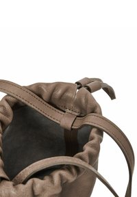 Borsa a tracolla in pelle marrone con una texture arricciata, interno morbido e due cinturini per la chiusura. Forma compatta con design senza cuciture.