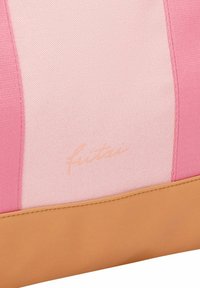 Canvas tas met roze en lichtroze panelen, beige onderkant en een gegraveerd logo. Heeft een gladde textuur en een gestructureerd ontwerp.