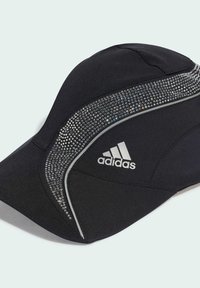 Čierna športová čiapka vyrobená z látky s lesklou textúrou. Obsahuje zvýraznenie z kamienkov pozdĺž jednej strany a strieborné logo.