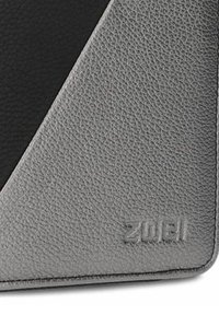 Portafoglio in pelle grigia texturizzata con un design geometrico nero e il logo embossato "ZUEI". Presenta un bordo liscio e una forma triangolare.